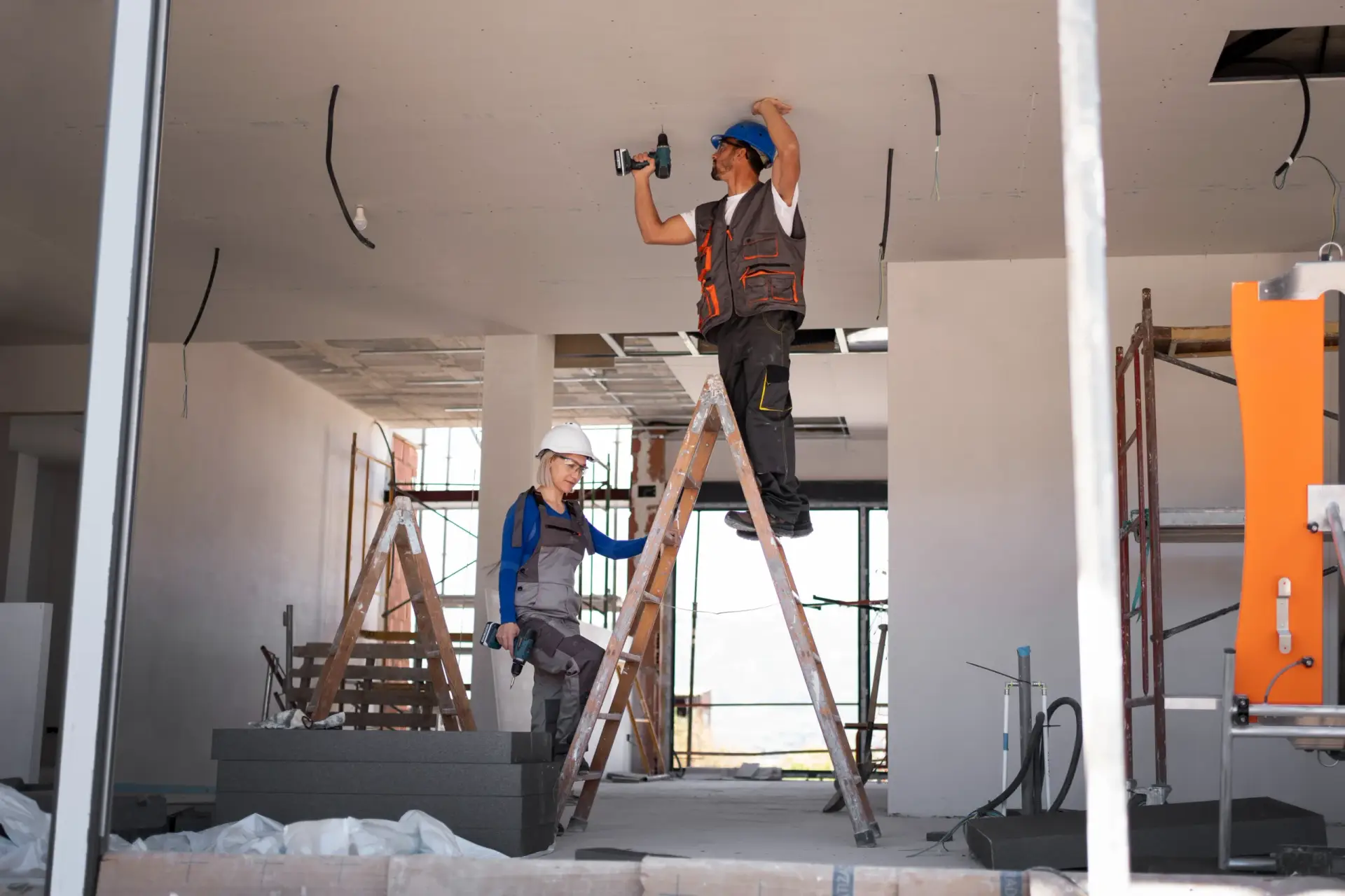 Two contractors on ladders installing drywall panels during a project for Home Remodeling in South Carolina.