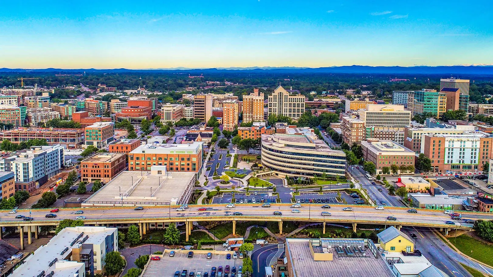 Aerial skyline view of buildings and lush greenery in the city served by Custom Home Builders in Greenville SC.