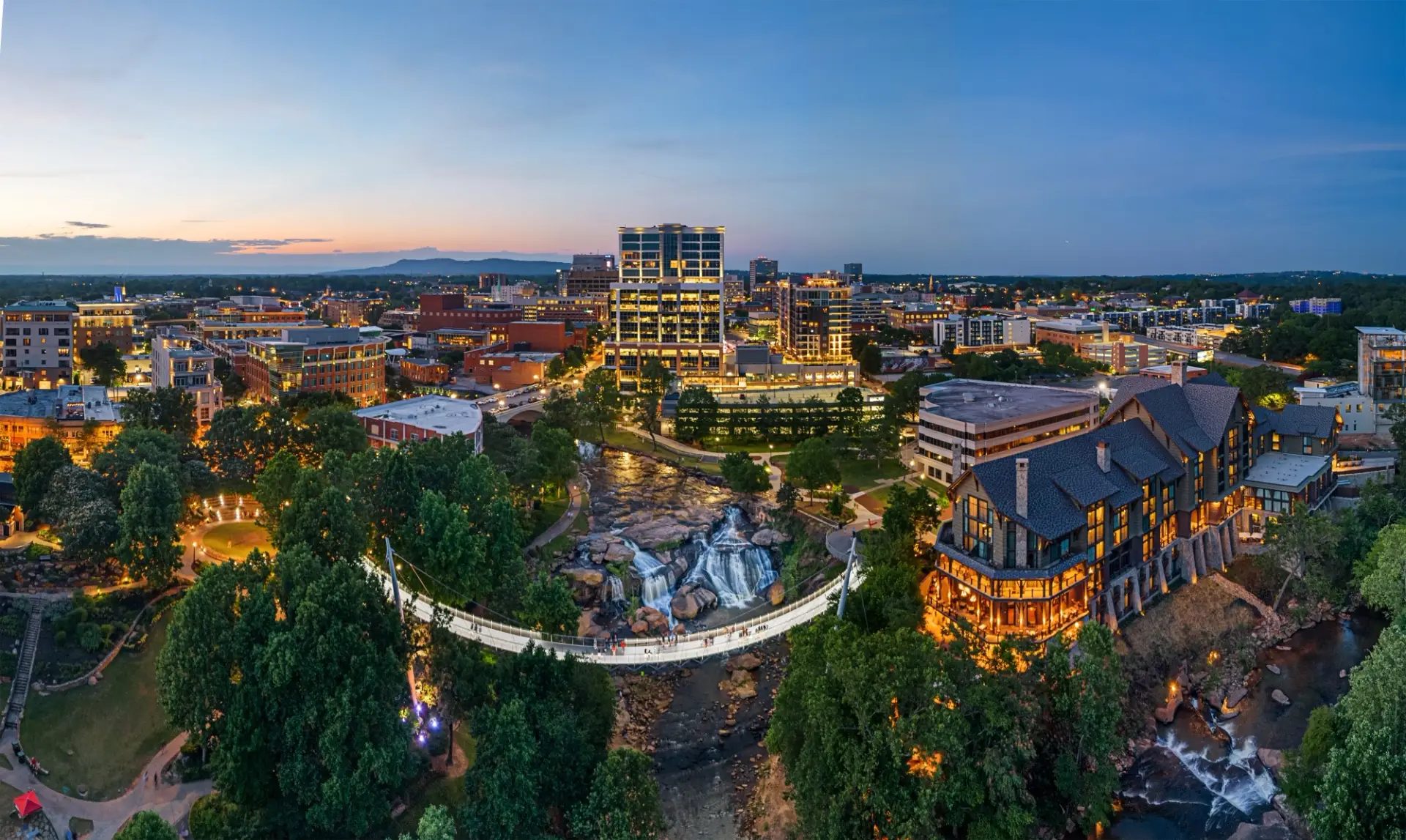 Liberty Bridge and Reedy River Falls at dusk, showcasing work by Custom Home Builders in Greenville SC.