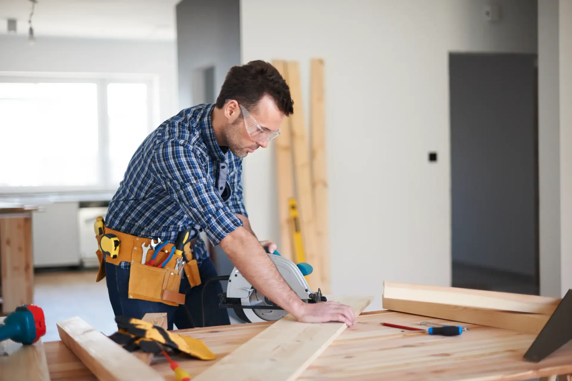 A carpenter using a circular saw on a wooden plank during a project for Home Remodeling in South Carolina.