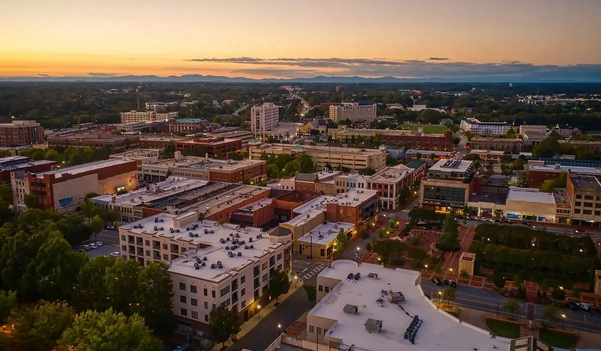 City buildings at sunset under an orange sky near areas served by Custom Home Builders in Spartanburg SC.